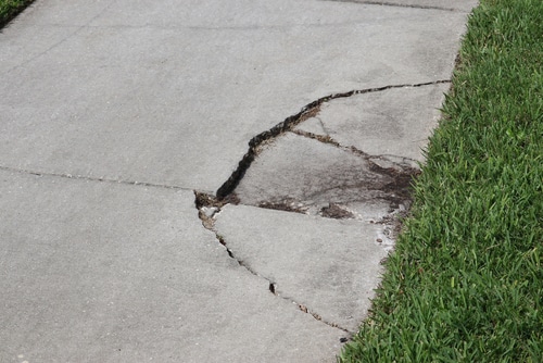 Broken,And,Cracked,Sidewalk,Near,Grass - Long Island Slip and Fall Lawyers Injury Attorney The Matera Law Firm